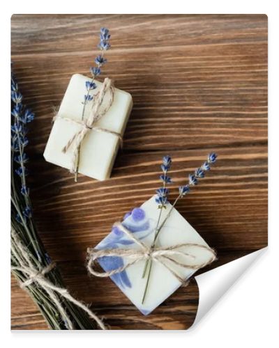 Top view of lavender flowers near handmade soap on wooden surface 
