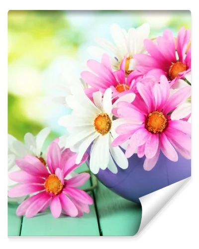 Pot with flowers on a wooden table on the nature background