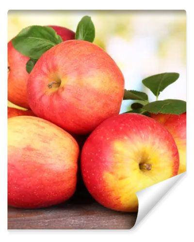 Ripe sweet apples with leaves on nature background