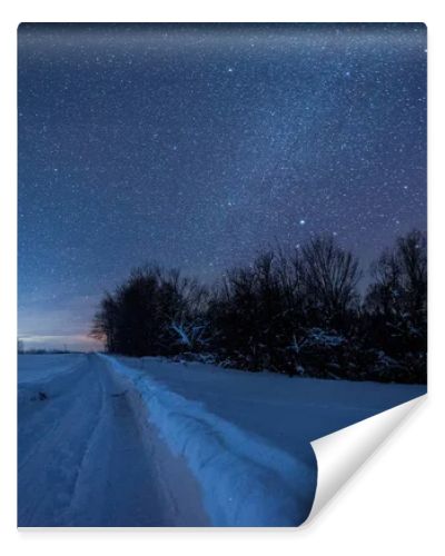 starry dark sky and snowy road in carpathian mountains at night in winter