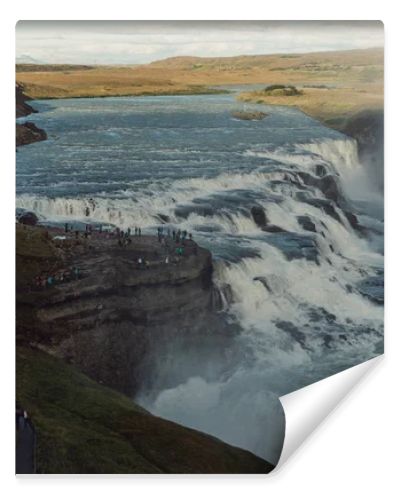 group of tourists looking at majestic waterfall in Iceland 