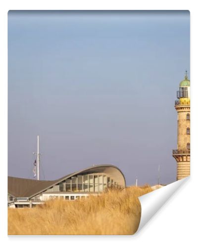 Lighthouse in Warnemuende, Germany with marram grass on sand dunes on the foreground. High quality photo