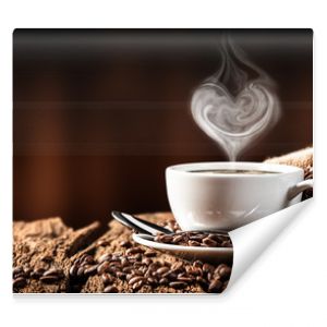  White Cup Of Hot Coffee With Heart Shaped Steam On Old Weathered Table With Burlap Sack And Beans
