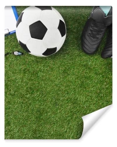 clipboard with soccer ball and boots on grass