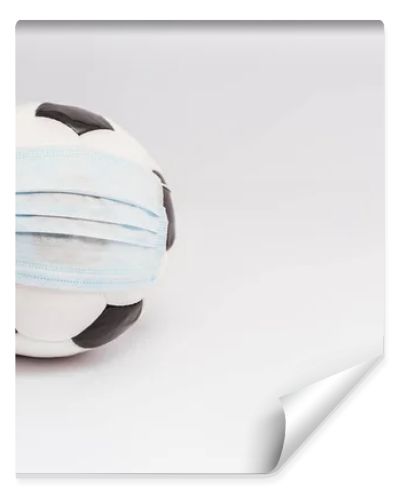 soccer ball in medical mask on white with copy space