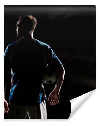 silhouette of football player standing with ball on black with smoke  