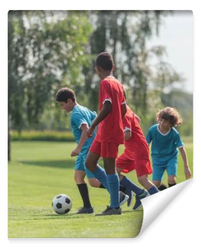 cute kids playing football with african american friend 