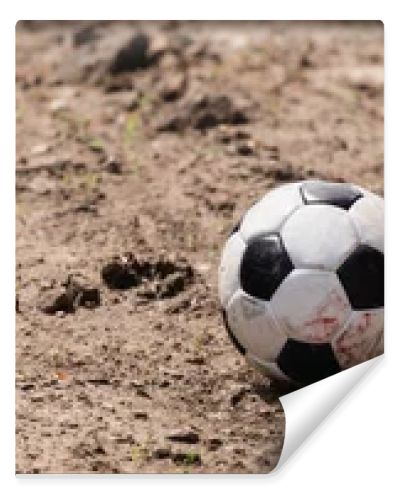 Panoramic shot of football on dirty road on urban street 