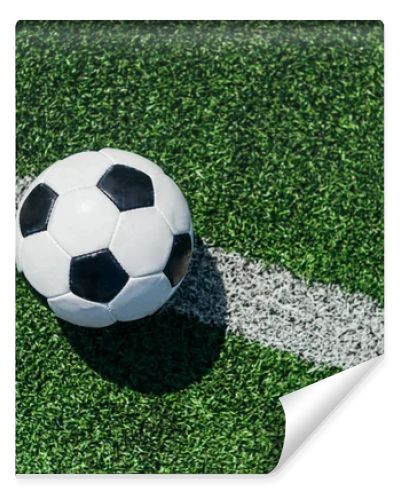 top view of football ball on green grass with white line