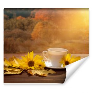 filiżanka kawy w jesienny poranek kawa o poranku i żółte kwiaty słonecznika i jesienny widok na las