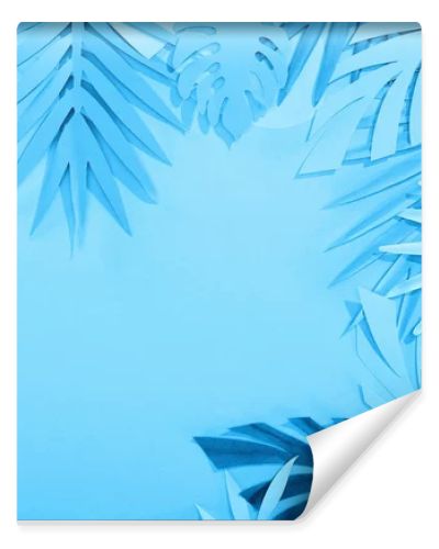 frame of paper leaves on blue minimalistic background with copy space