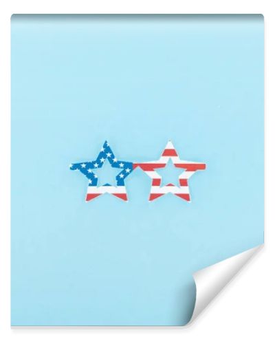 top view of paper cut decorative glasses made of american flag on blue background 