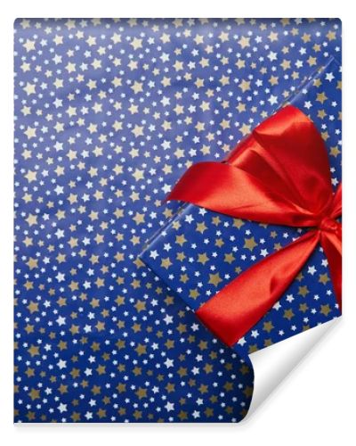 top view of wrapped gift box with red ribbon on festive wrapping paper with stars pattern