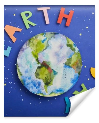 top view of colorful paper letters and planet picture on violet background with stars, earth day concept