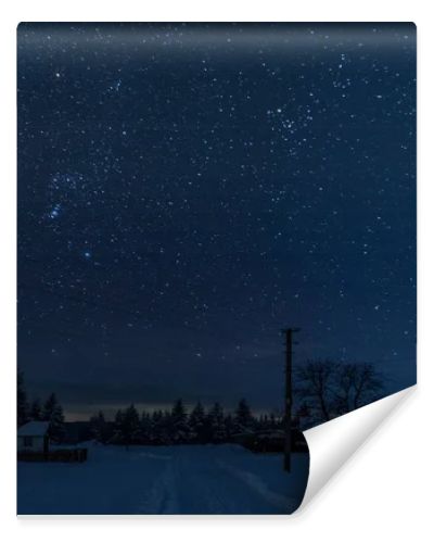 starry night sky above village covered with snow in carpathian mountains