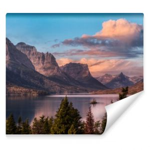 Beautiful Panoramic View of a Glacier Lake with American Rocky Mountain Landscape in the background. Dramatic Colorful Sunrise Sky. Taken in Glacier National Park, Montana, United States.