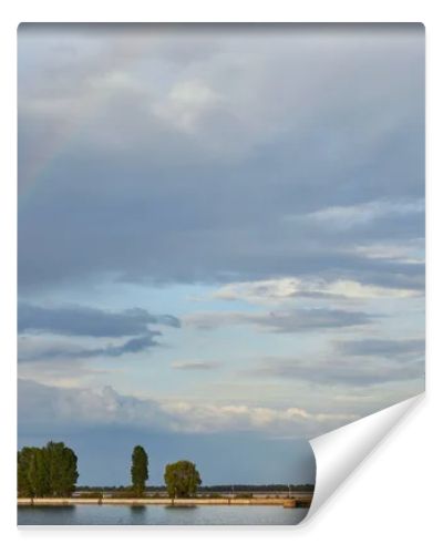 landscape of blue sunlight sky, rainbow, river and coast with trees