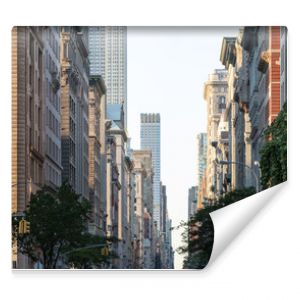 View down Fifth Avenue in Manhattan, New York City with historic buildings lining both sides of the street in NYC