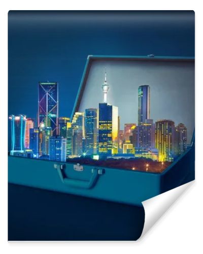 Night scene modern city skyscrapers in an open retro vintage suitcase isolated on blue background 