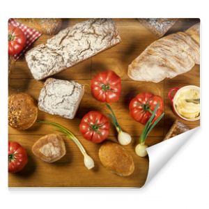 Chleby, pomidory i cebulki - kompozycja na drewnianym stole