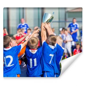 Młoda drużyna sportowa z trofeum Chłopcy świętują osiągnięcia sportowe Młodzi piłkarze trzymający trofeum świętują piłkę nożną Piłka nożna