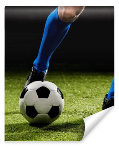 cropped view of sportsman playing with ball on green grass isolated on black