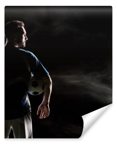 silhouette of football player holding ball on black with smoke  