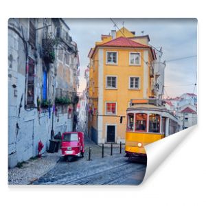 Old tram and tuk-tuk on a street in Lisbon.