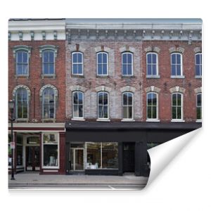 facade of old brick buildings with stores at street level and apartments above