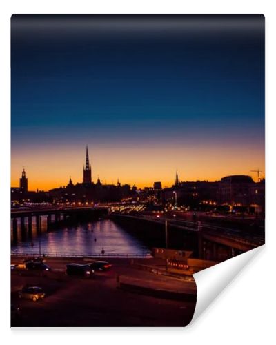 Silhouette of Stockholm cityscape skyline with Riddarholmen Church spires, City Hall Stadshuset tower, bridge over Lake Malaren in Gamla Stan at sunset, dusk, twilight and blue orange sky, Sweden