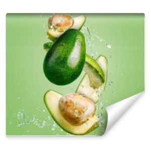 Fresh avocado cut into slices with water drops splash flying in the air and levitate on a mint green background. Healthy diet ingredient recipe. Trendy motion food composition. Creative fruit concept.