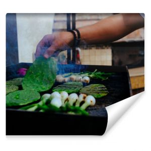 Man grilling fresh vegetables on barbecue in backyard