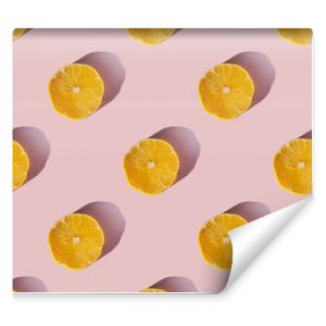 Uniform pattern of dried lemon slices with shadow on a pink background. Flat lay