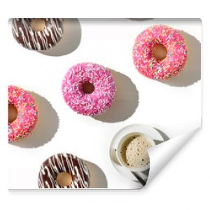 A cup of coffee and a variety of donuts on a white background. Flat lay composition with coffee and donuts.