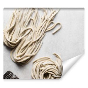 Fresh homemade noodles on white marble board, floured fresh noodles