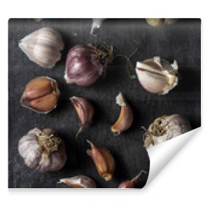 Fresh garlic bulbs and cloves grouped on black background