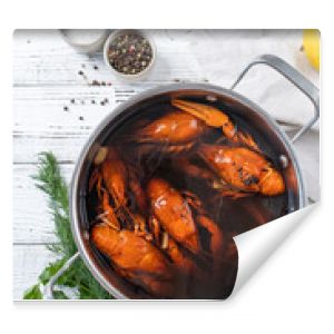 cooked crawfish in saucepan with lemons and spices on wooden background