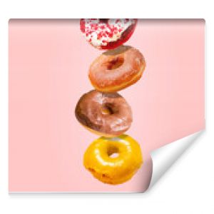 Levitating donuts isolated on a pink background. Modern food concept. Advertising for pastry shops, cafes.