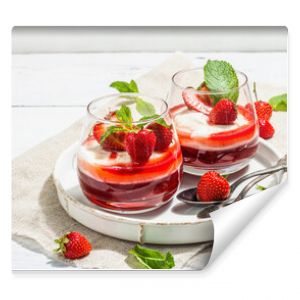 Italian dessert panna cotta in glass with strawberries. Healthy sweet food, hard light, dark shadow