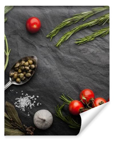 Herbs mix with tomatoes, lemon and olive oil on the black stone table