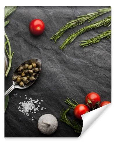 Herbs mix with tomatoes and olive oil on the black stone table