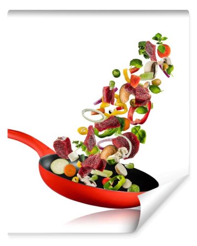 Fresh vegetables and beef meat flying into a pan on white background