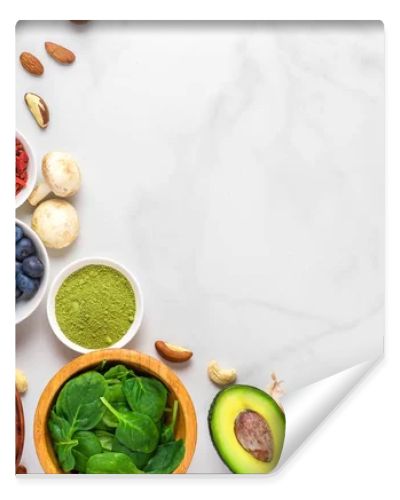 Healthy vegan food clean eating selection: fruit, vegetable, seeds, superfood, nuts, berries on white marble background