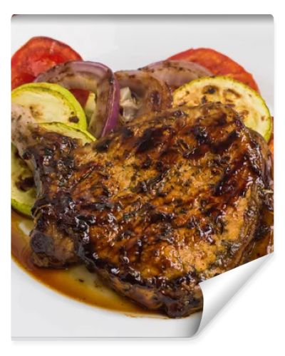 Pork steak on the bone grilled with vegetables. Wooden background. Top view. Close-up