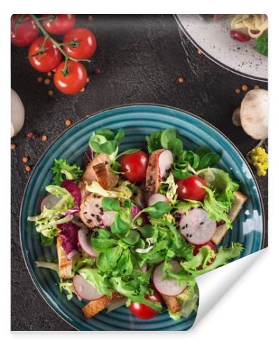 Fresh vegetable salad with grilled chicken breast - tomatoes, radish and mix lettuce leaves. Chicken salad. Healthy food. Black background. Top view