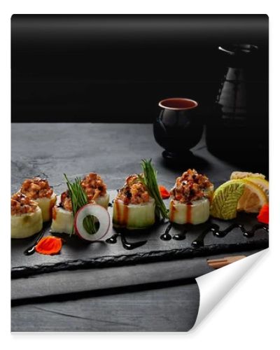 gourmet sushi roll with creamy eel and kimchi mayonnaise on slate board and chopsticks  