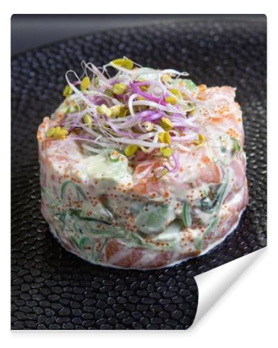 Tartar with salmon and avocado on a black plate