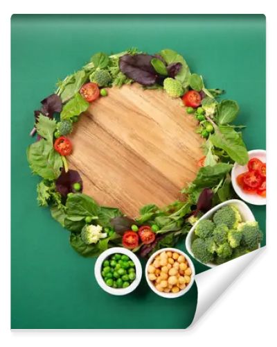 Vegetarian and vegan diet month in january called Veganuary. Variety of vegan, plant based protein food, healthy raw vegetables. Top view on green background.