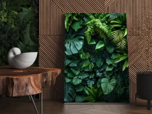 Dark green plants growing in a lush foliage background of tropical leaves like anthurium, epiphytes, or ferns, forming a beautiful green plant wall design in a cloud forest.