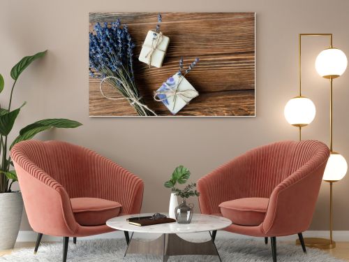 Top view of lavender flowers near handmade soap on wooden surface 